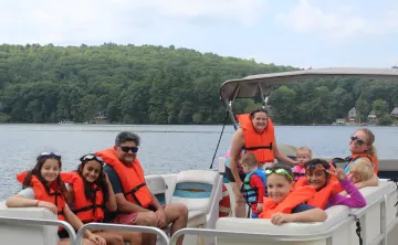 Camp Frank A. Day family camp participants on a pontoon boat ride