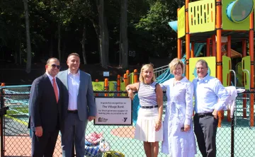Village Bank representatives with the sponsor plaque at the new WSYMCA playground and splashpad