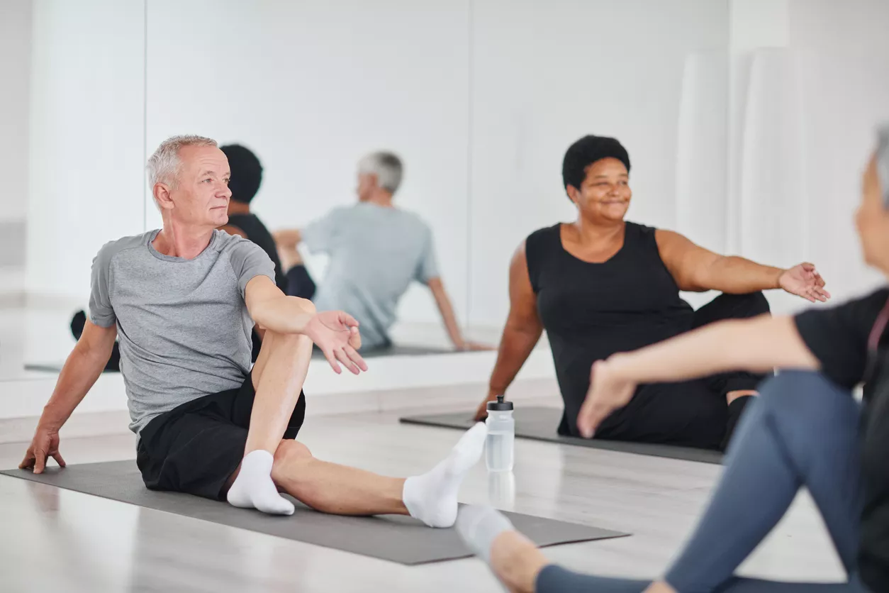 A man and woman participate in a yoga class. 