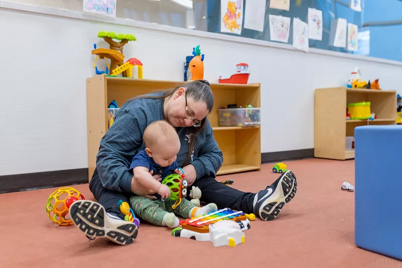 A YMCA employee cares for an infant. 