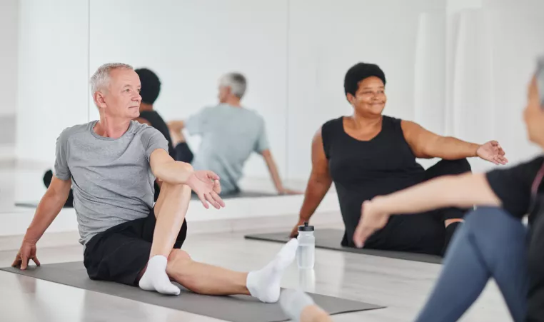 A man and woman participate in a yoga class. 