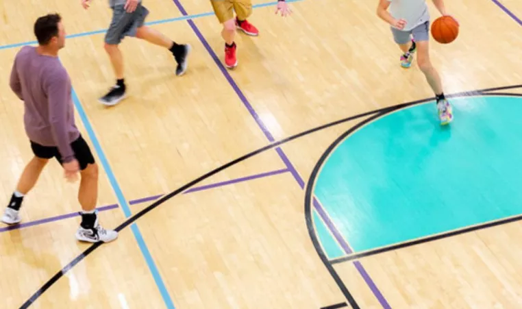 A group of young men play pick up basketball at the YMCA. 