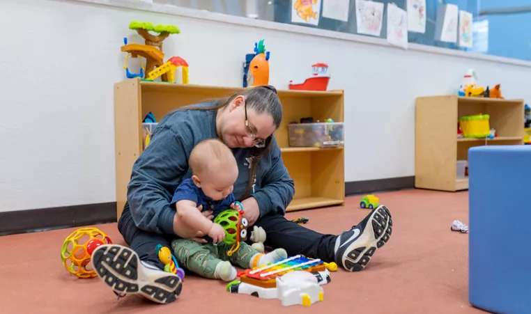 A YMCA employee cares for an infant. 