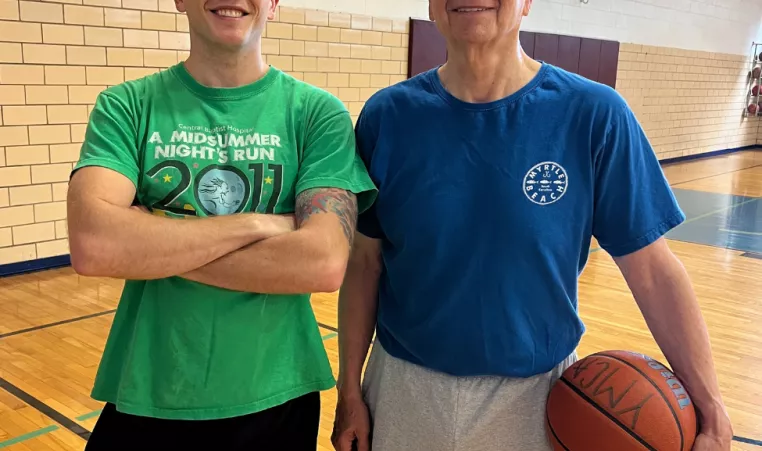 A young man and his grandfather pose in the gymnasium at the High Street YMCA.