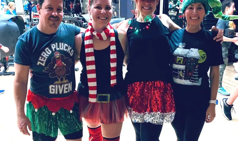 Four friends dressed in festive holiday gear enjoy a group exercise class at the YMCA of Central KY