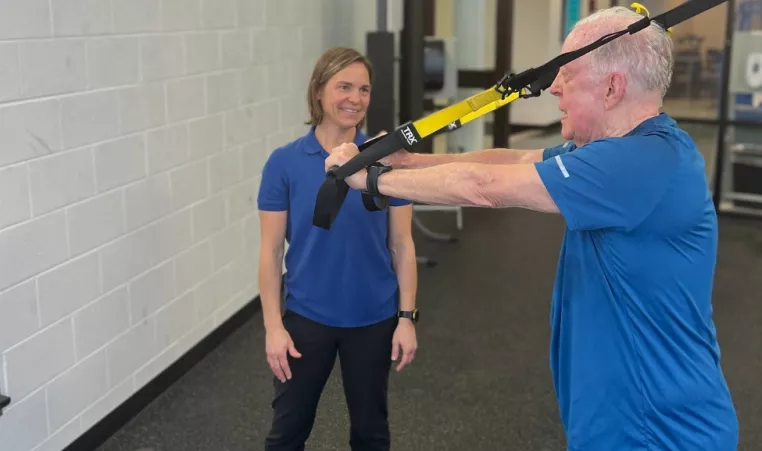 Personal Trainer supervises a client getting stronger at the YMCA of Central Kentucky