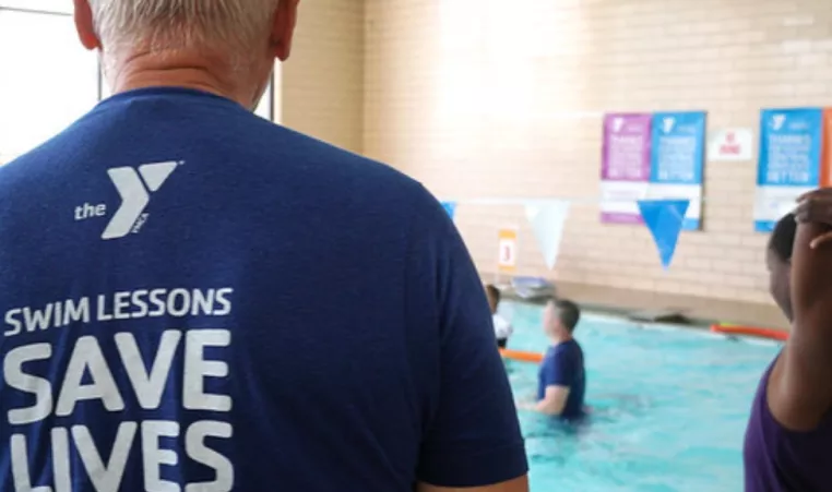 YMCA pool scene with adults supervising children to keep everyone safe in the water. 