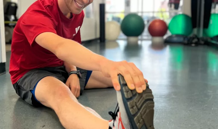 A YMCA member stretches after a workout as part of his post-workout recovery routine.