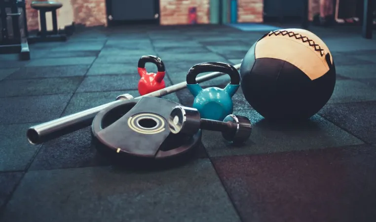 Medicine ball and barbell on a gym floor. 