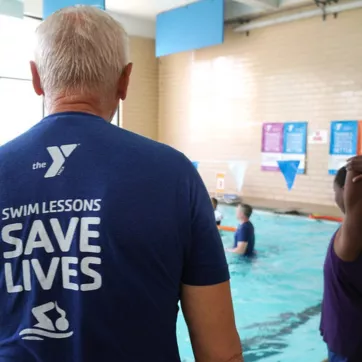 YMCA pool scene with adults supervising children to keep everyone safe in the water. 