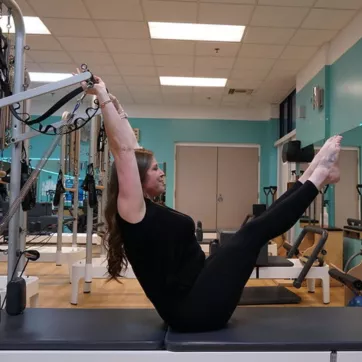 Pilates Instructor demonstrates a Reformer move at the YMCA of Central KY