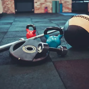 Medicine ball and barbell on a gym floor. 