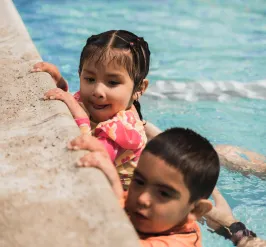 children holding the wall during swim lessons