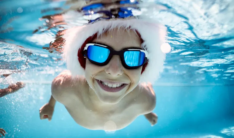 Boy swimming with Santa Hat