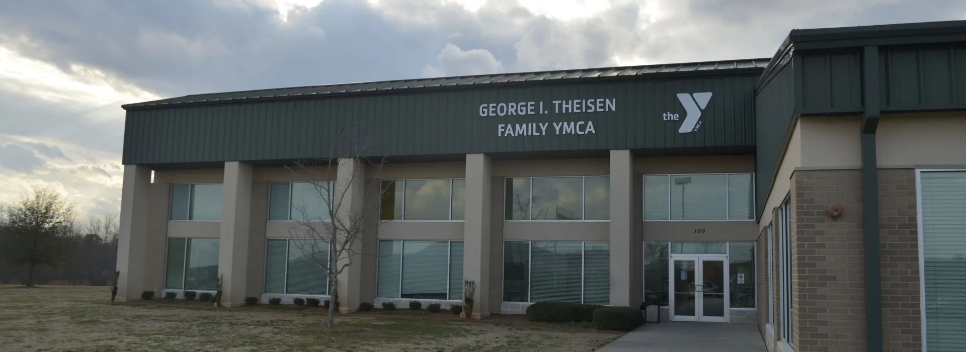 The sun peeks through the clouds behind the George I Theisen Family YMCA