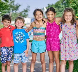 Five kids smiling in front of park