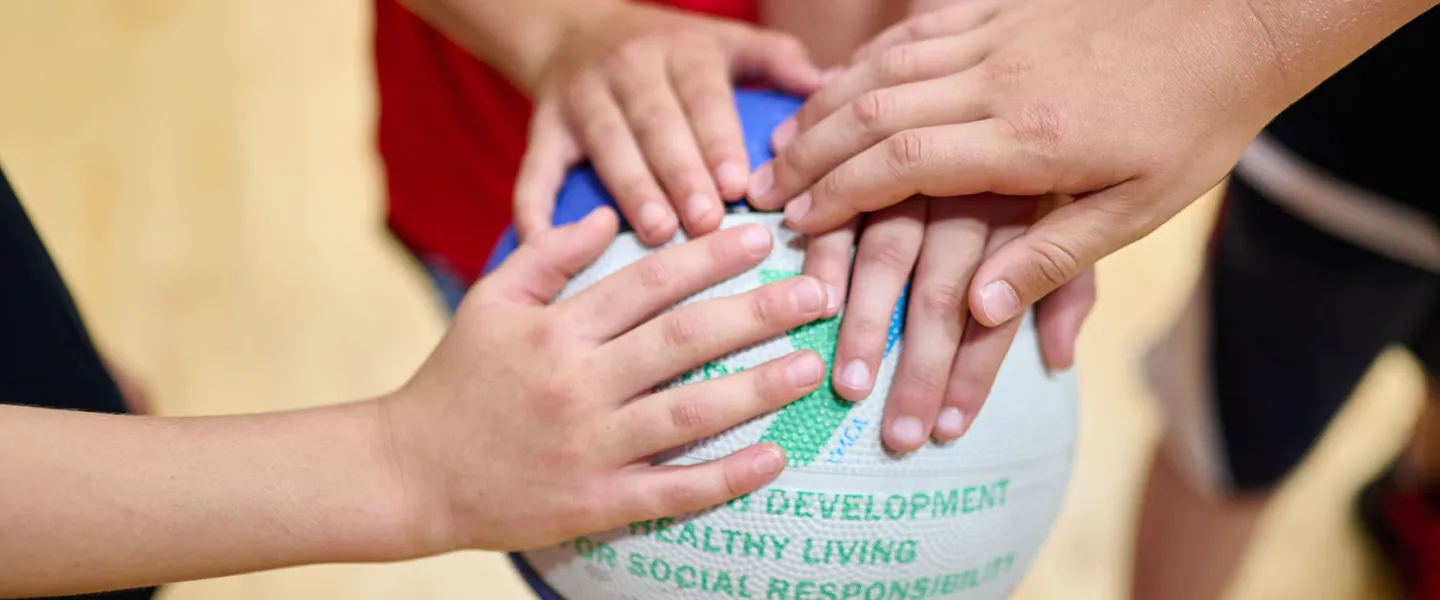 children's hands on a basketball