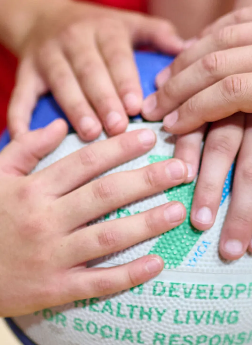 children's hands on a basketball