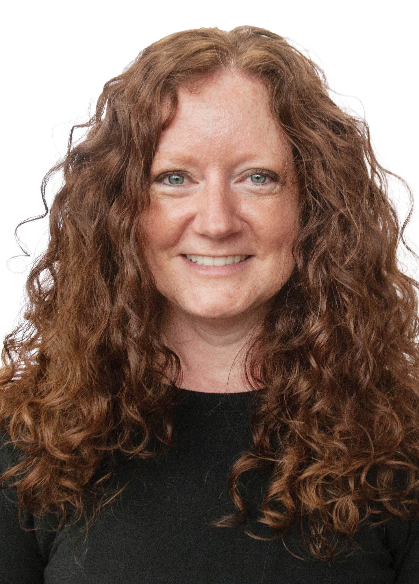 a headshot of woman with long red curly hair and green eyes. she is wearing a black shirt.