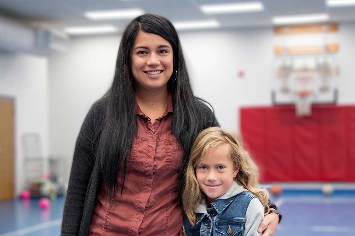 Mom hugging child in gym background
