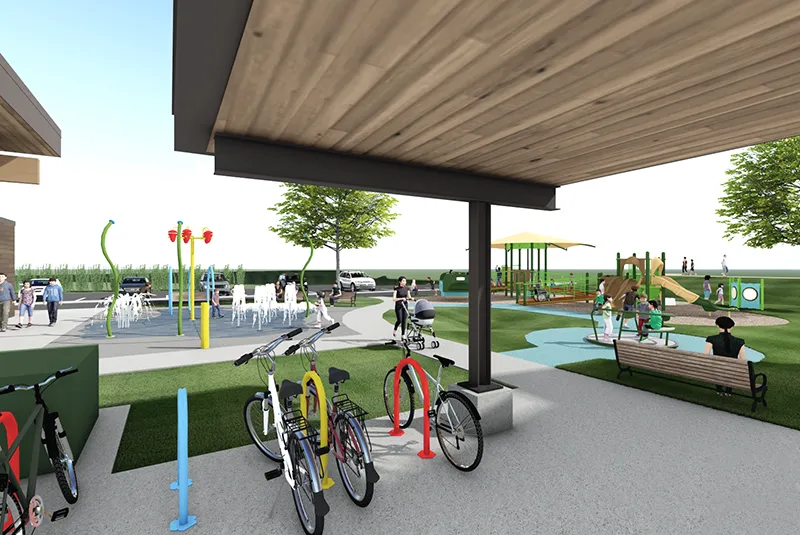 rendering of a community splash pad and all-abilities playground. the view is from the vantage point of a covered bike storage area.