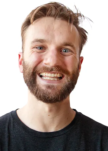 professional headshot of a smiling man with sandy blond hair and a reddish beard