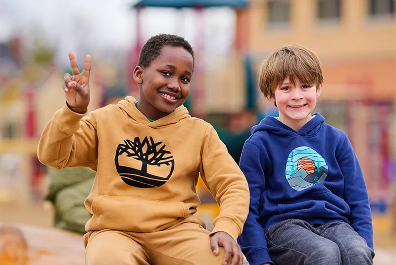 two children sitting next to each other smiling