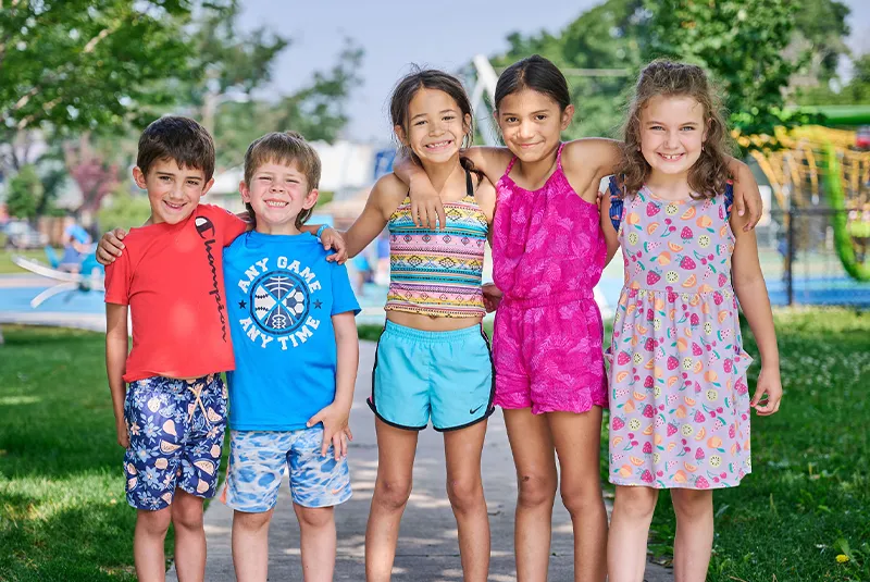 Five kids smiling in front of park