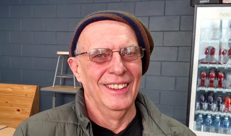older man wear a winter hat and glasses smiling