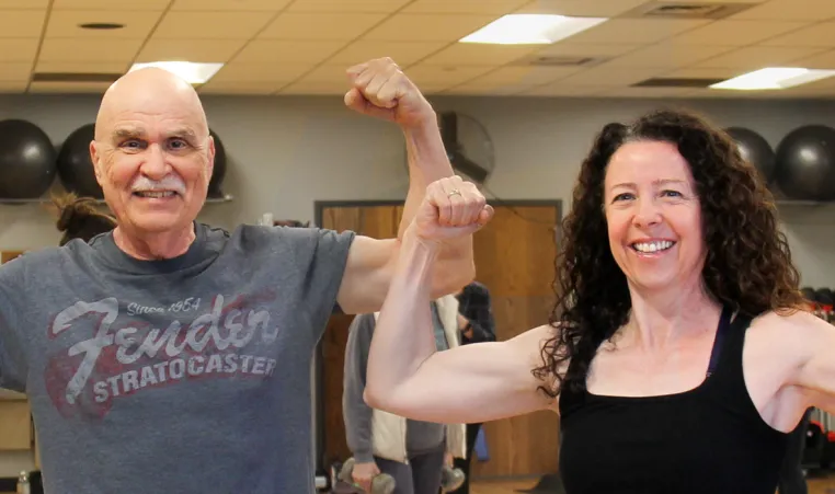 Two people flexing arms in group fitness class at the Missoula YMCA
