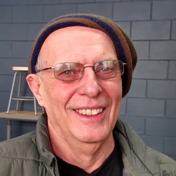 older man wear a winter hat and glasses smiling