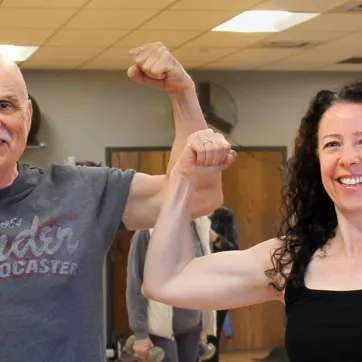 Two people flexing arms in group fitness class at the Missoula YMCA