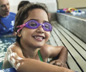 young child wearing swim goggles in a swimming pool