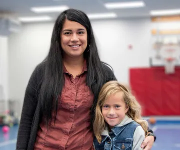 Mom hugging child in gym background